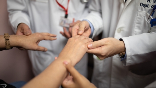 Physicians examine a patient's hands