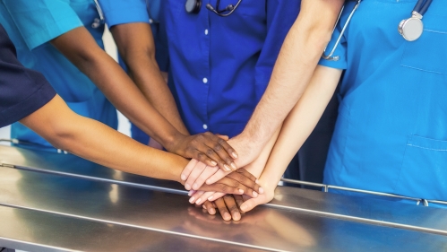 Medical school students stack their hands in teamwork
