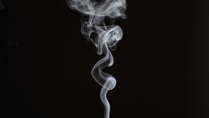 Smoke rises from a cigar