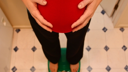 pregnant woman weighs herself