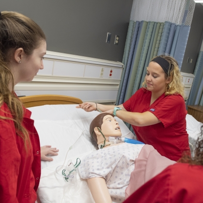 Nursing students practice on a simulation patient
