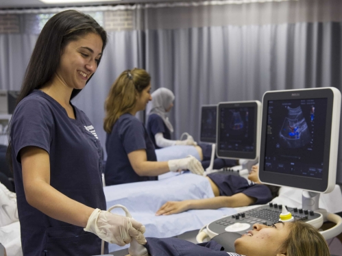 School of health professions radiology students practice using sonography equipment in a lab