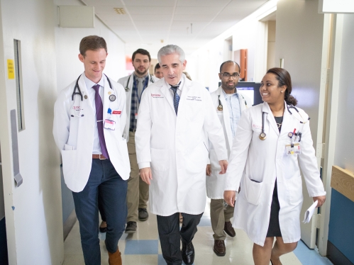 NJMS medical students walk down a hospital hallway