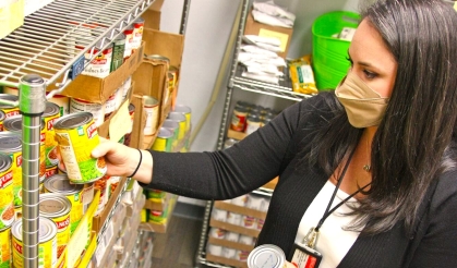 a person stocking canned food on shelves